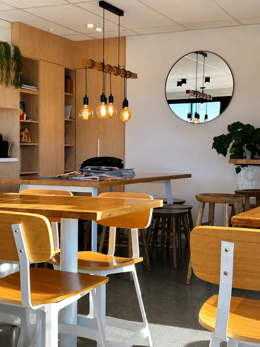 Warm timber tables, pendant lights and greenery inside Kawakawa at Salt