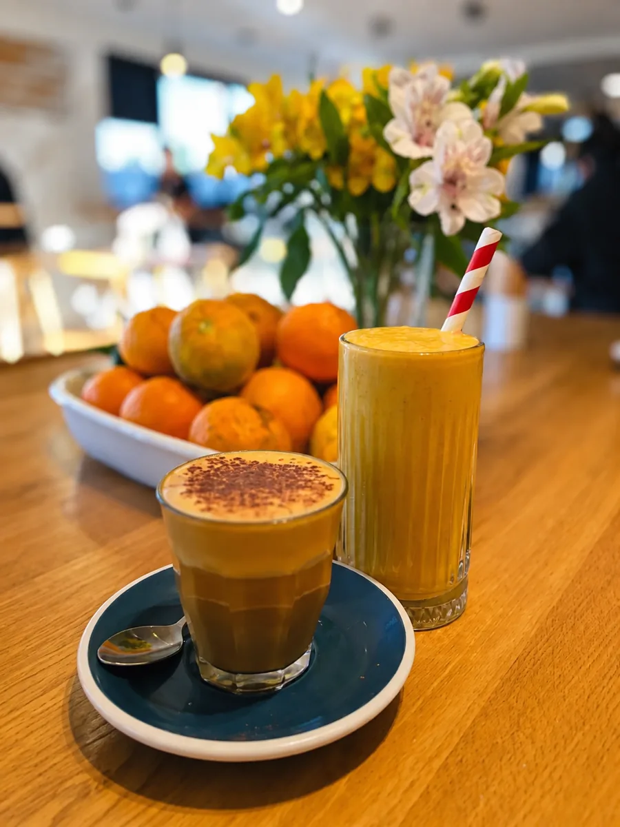 Coffee and a bright fruit drink on a cafe table